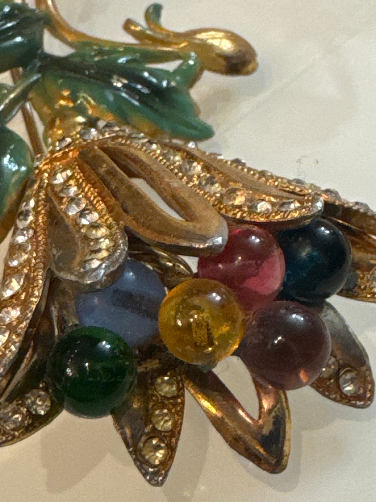 Coro floral spray brooch, late 1950s–early 1960s, featuring molded lucite leaves, multicolored glass bead berries, and rhinestone-set gold-tone petals. Hand-assembled with open architectural construction.