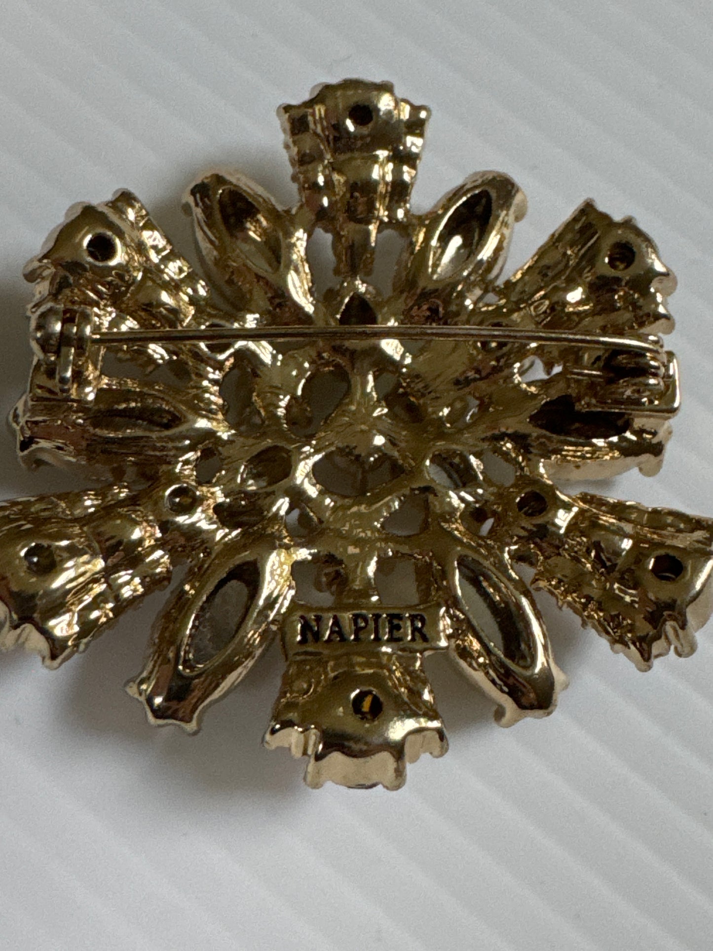 Signed vintage NAPIER gold tone brooch with light, green and light purple rhinestones
