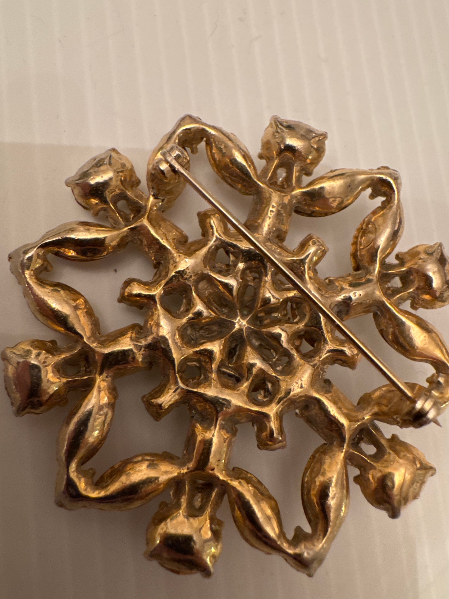 Unsigned brooch attributed to Schreiner New York, circa late 1950s. Identified by its unfoiled stones (creating a glow instead of a sparkle) dramatic mixed cuts, sculptural gold-tone casting, and signature dimensional construction