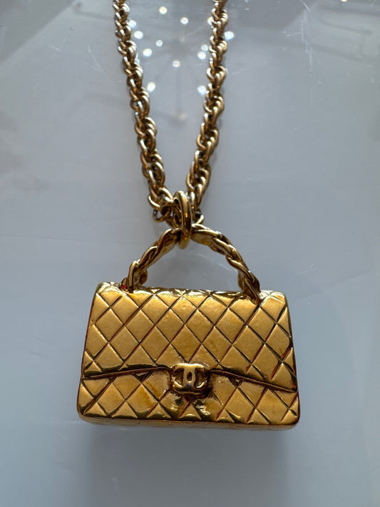 Beautiful gold tone, Chanel necklace with mini handbag pendant. Comes with box.