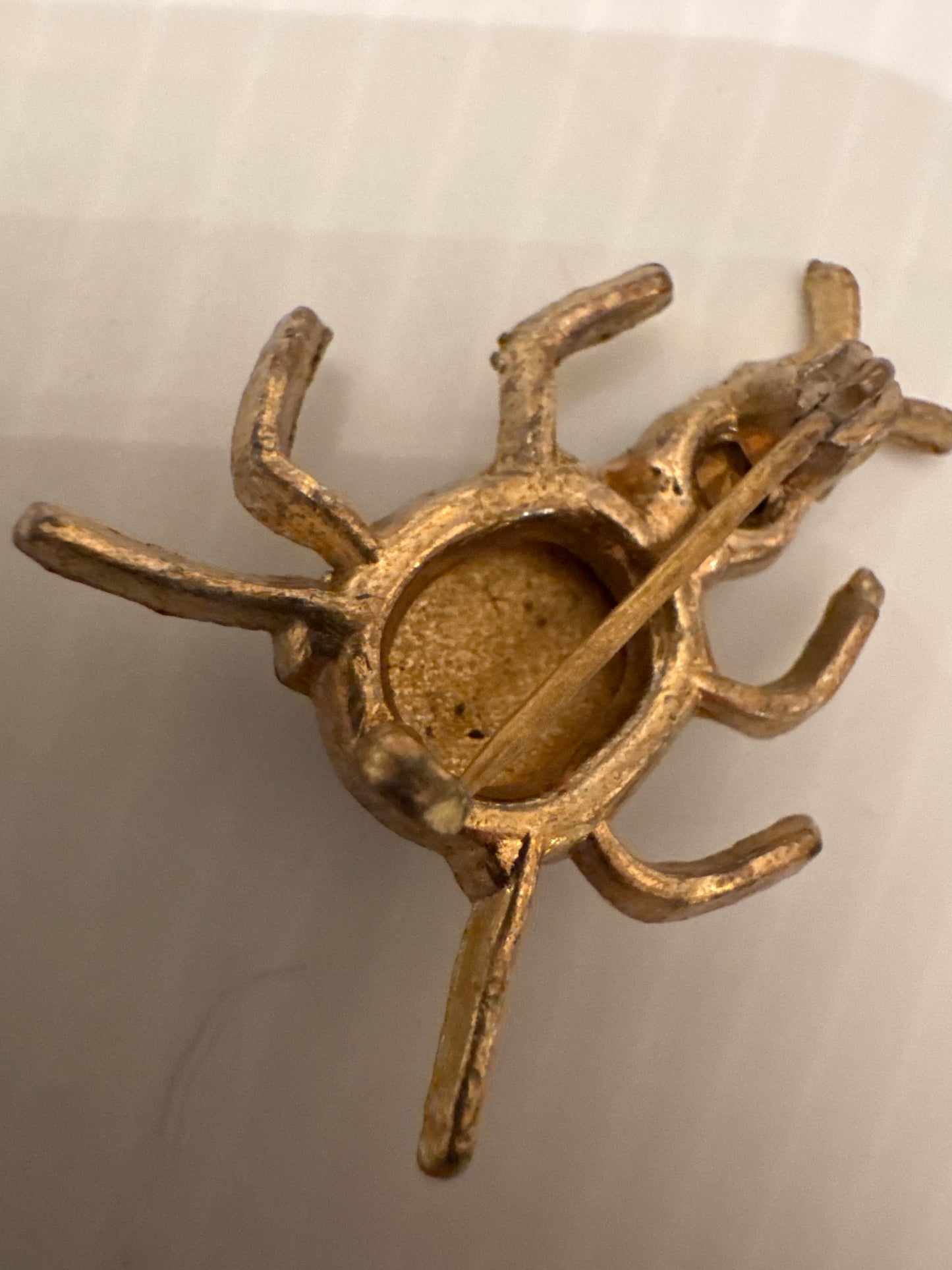 Unsigned vintage ant brooch, attributed to De Mario (NYC), circa late 1940s–early 1950s, identified by its deep cup-set cabochon body, emerald crystal head, and hand-finished gold-tone casting.