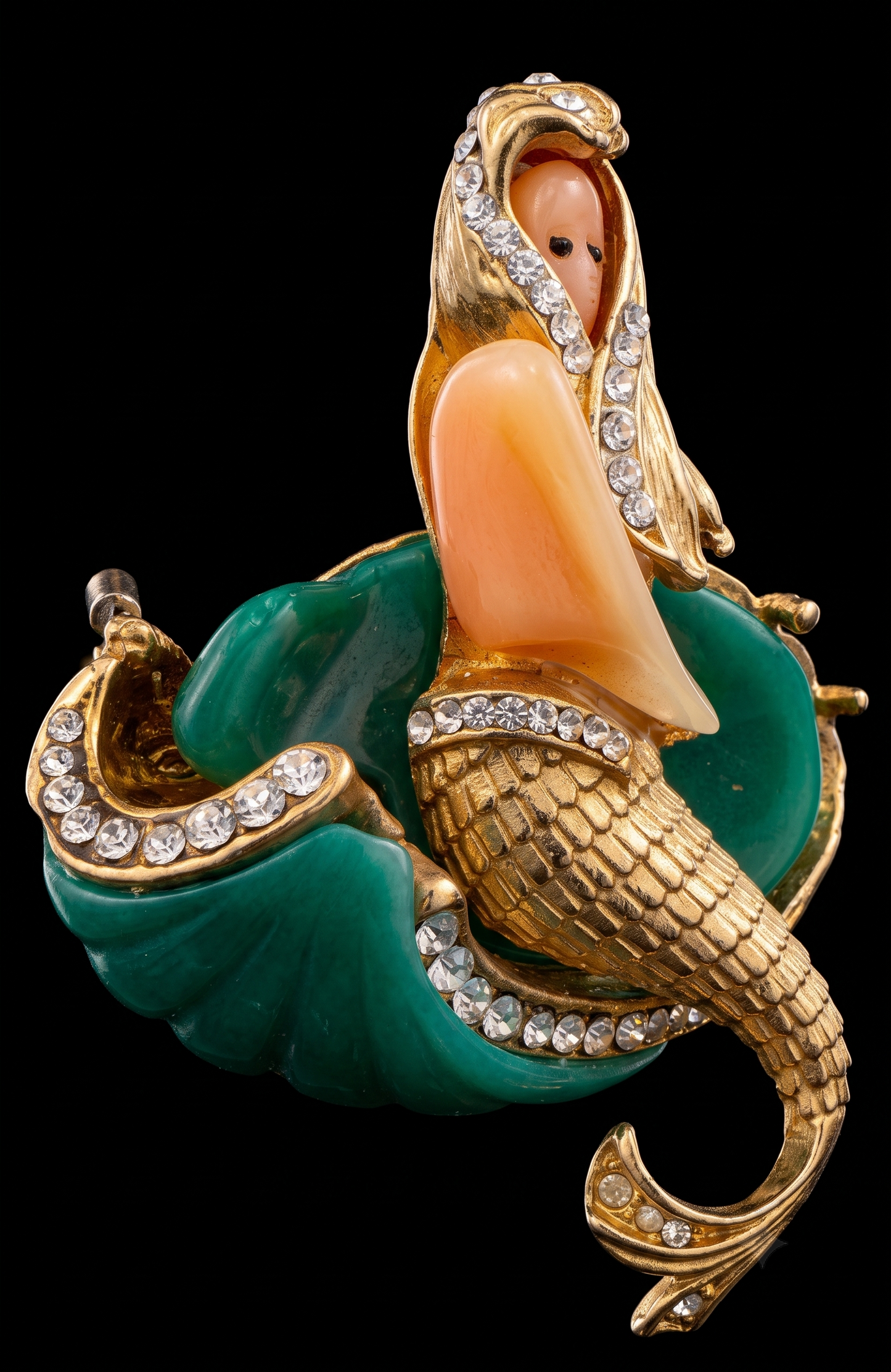 Attributed Hattie Carnagie mermaid brooch circa1960.
Carved lucite figure and wave, hand-set rhinestones, sculptural gold-tone metal. Unsigned, a strong example of mid-century fantasy figural jewelry.