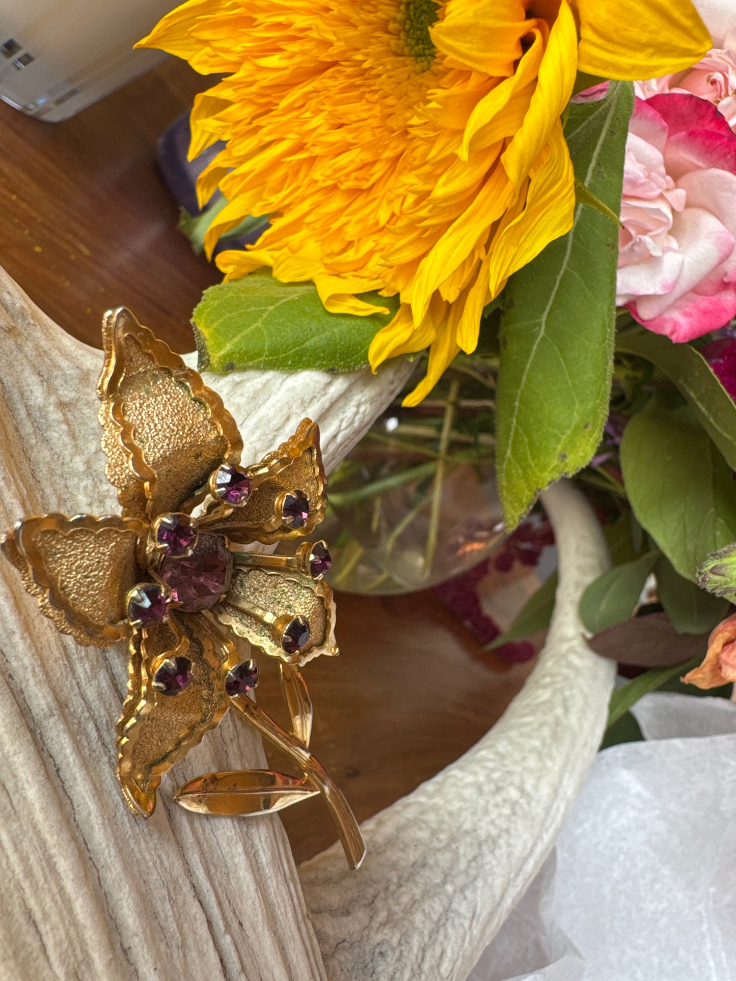 Gold tone and amethyst colored rhinestone flower brooch