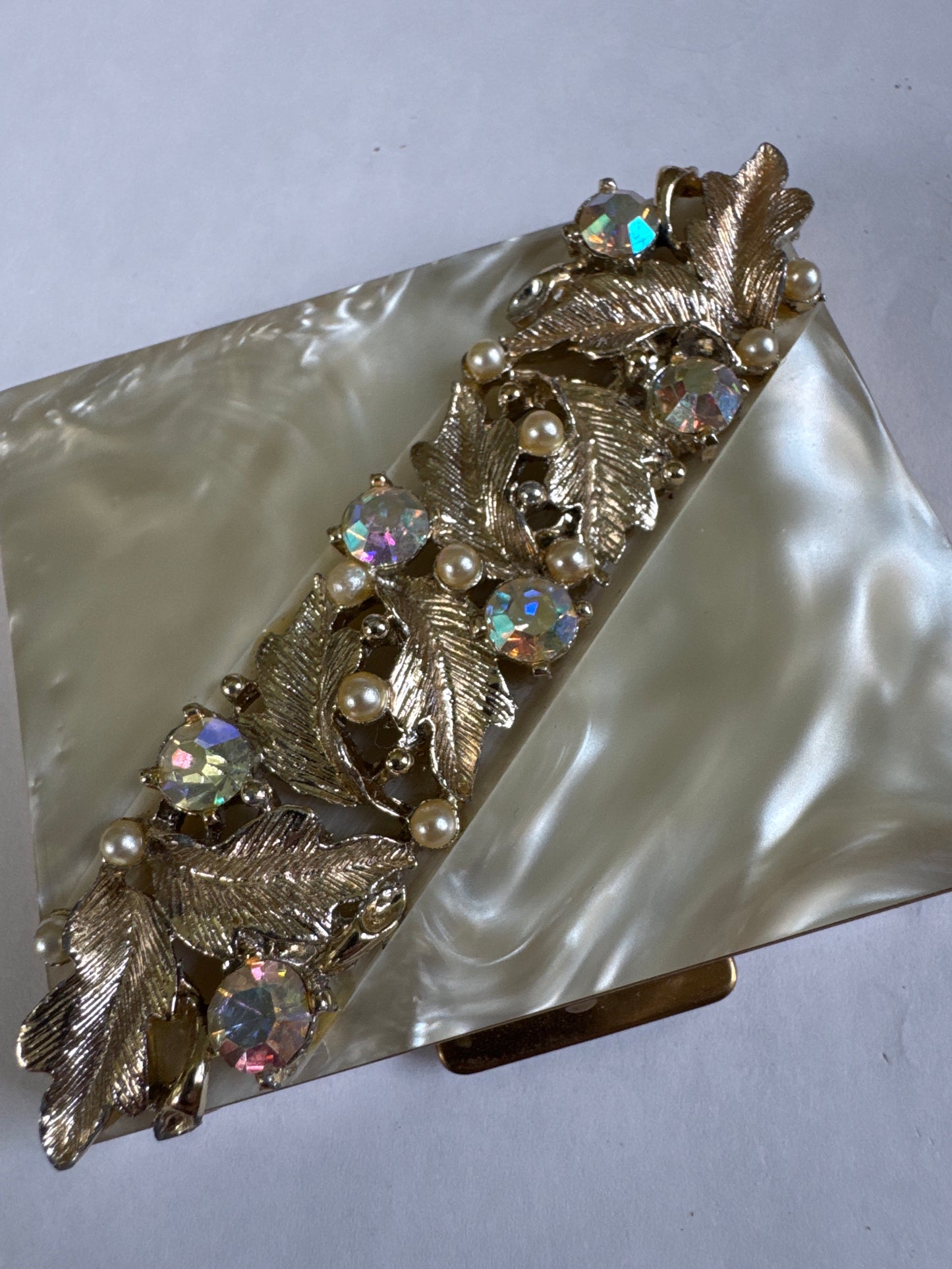 Beautiful 1940s mother-of-pearl Makeup compact with gold tone, leaf design aurora borealis stones and pearls signed S.F. Co 5th Avenue