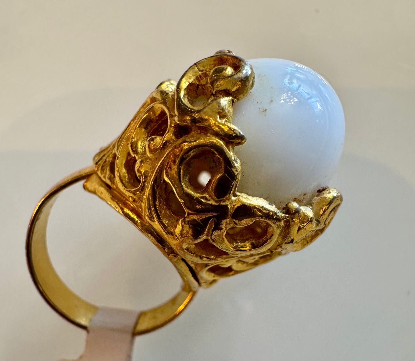 1960s gold tone swirl motif with white "gumball" stone