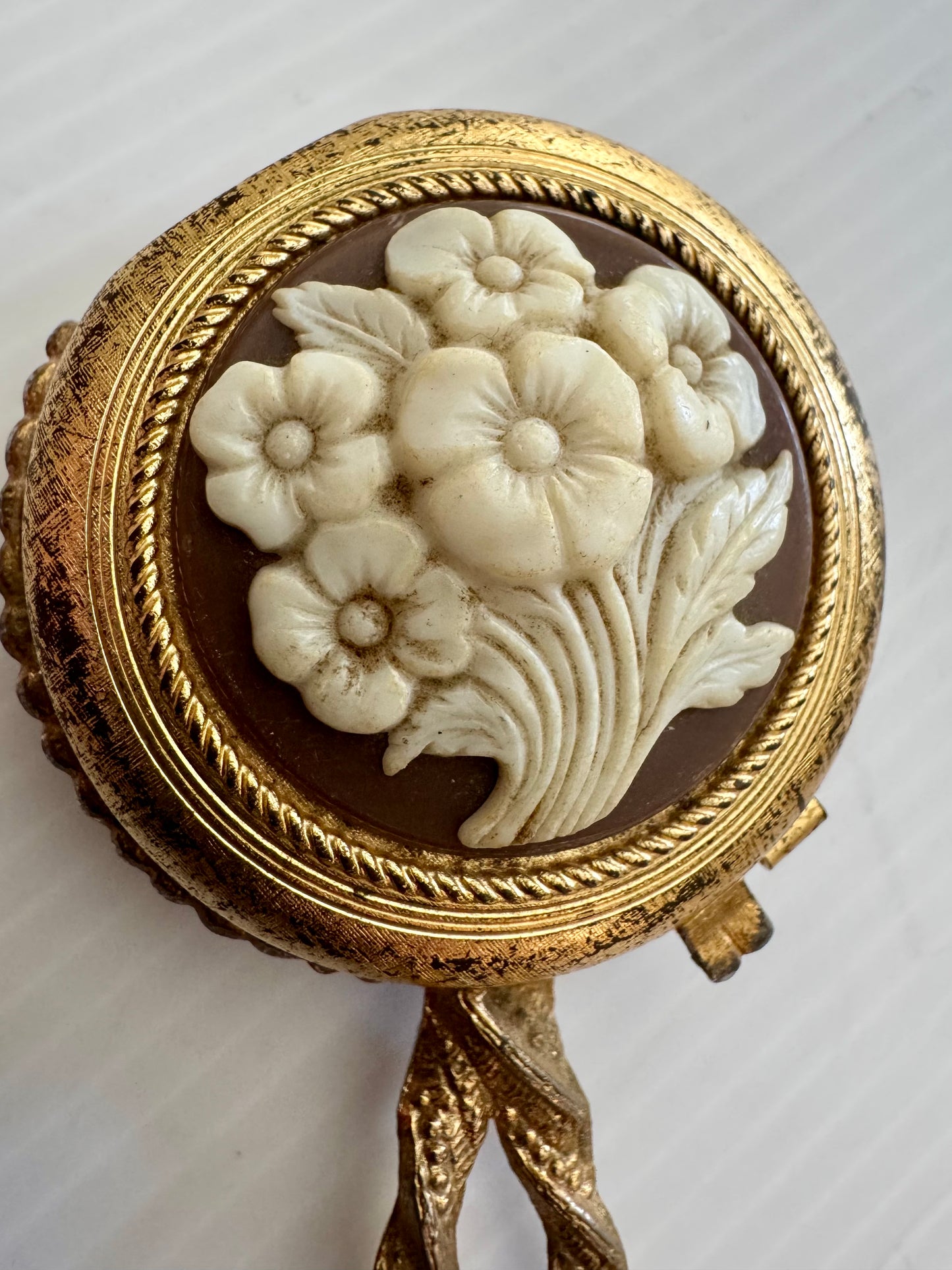 Beautiful vintage Makeup powder compact with inside and outside mirror. Gold tone handle, and flower cameo cover. Sourced in Paris.