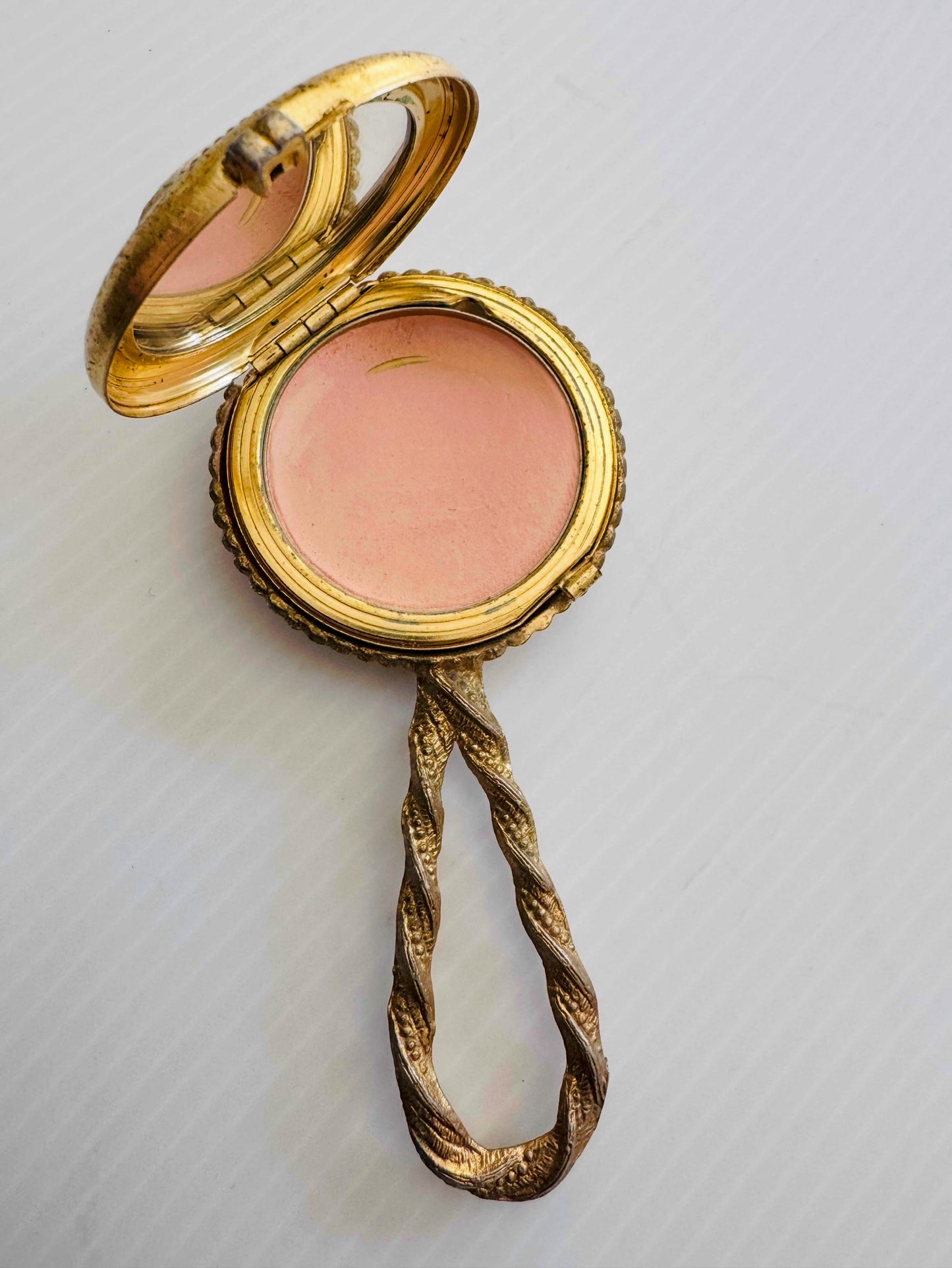 Beautiful vintage Makeup powder compact with inside and outside mirror. Gold tone handle, and flower cameo cover. Sourced in Paris.