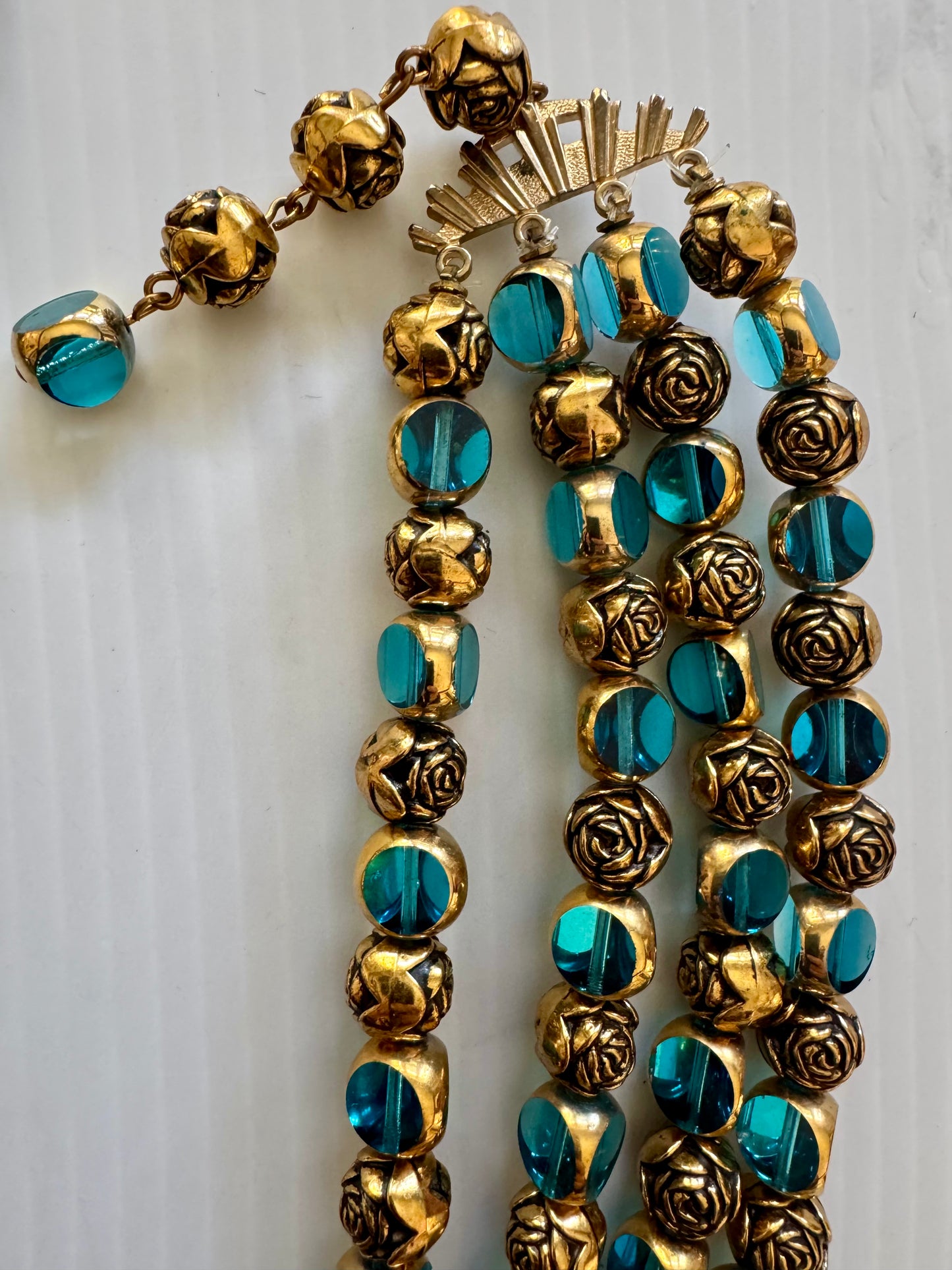 stunning vintage four strand, gold tone necklace with gold and turquoise beads. Sourced in Paris.
