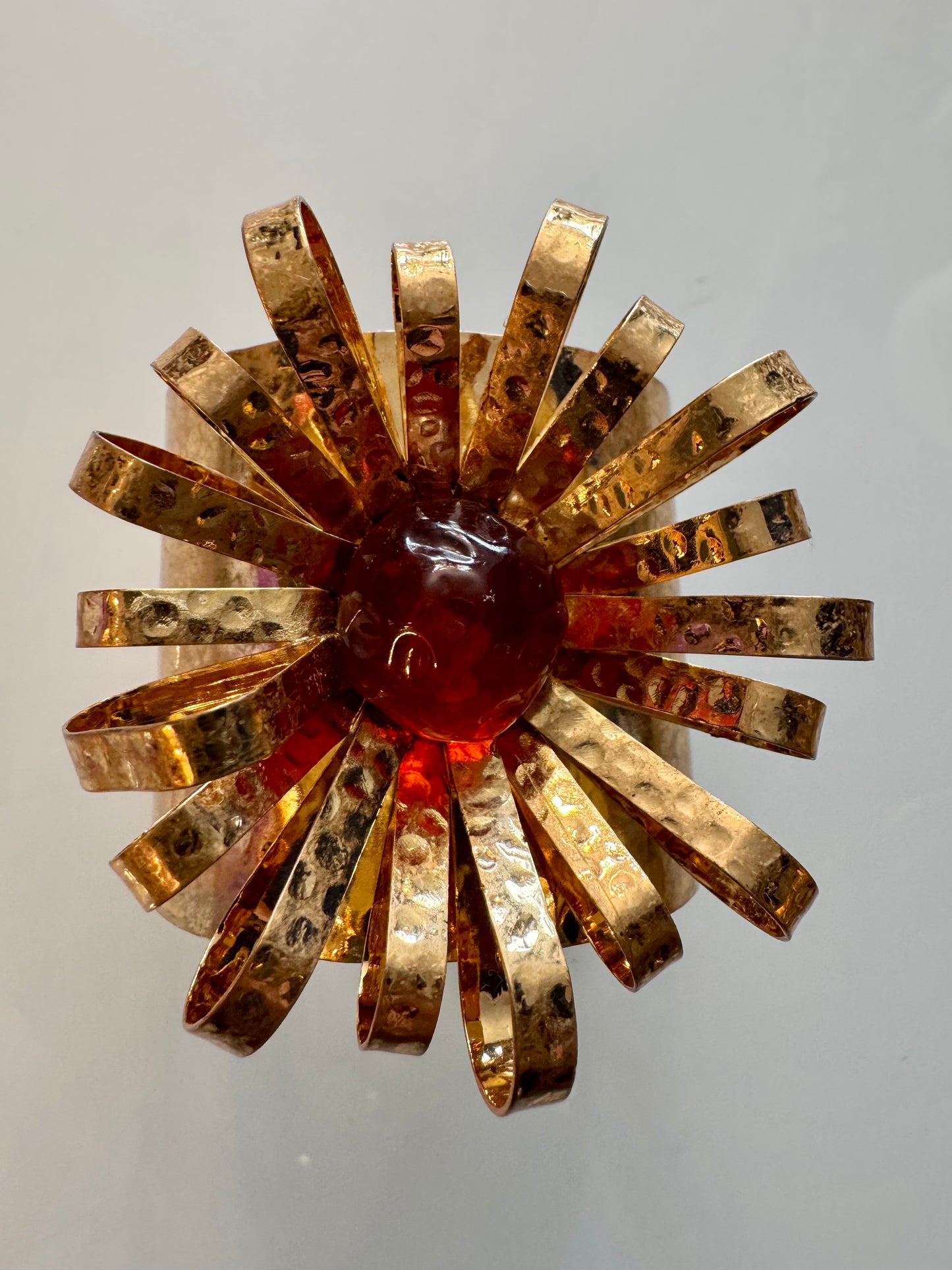 Adjustable hammered goldtone starburst cuff with red center stone