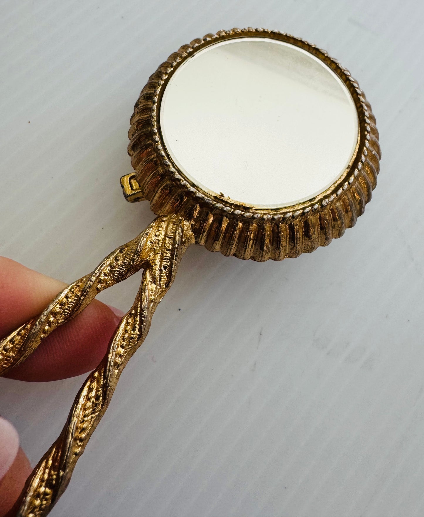 Beautiful vintage Makeup powder compact with inside and outside mirror. Gold tone handle, and flower cameo cover. Sourced in Paris.