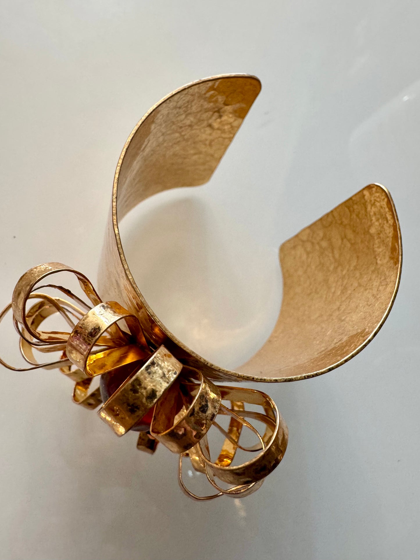 Adjustable hammered goldtone starburst cuff with red center stone