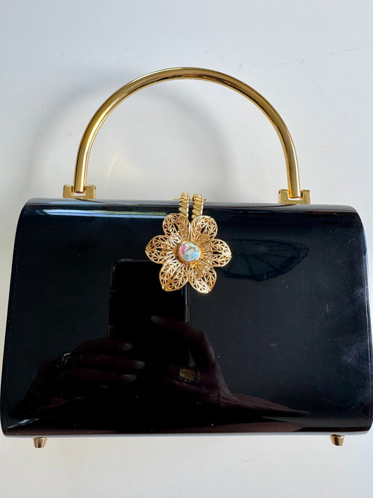 Beautiful 1960s black lucite handbag with gold top handle and decorative floral clasp