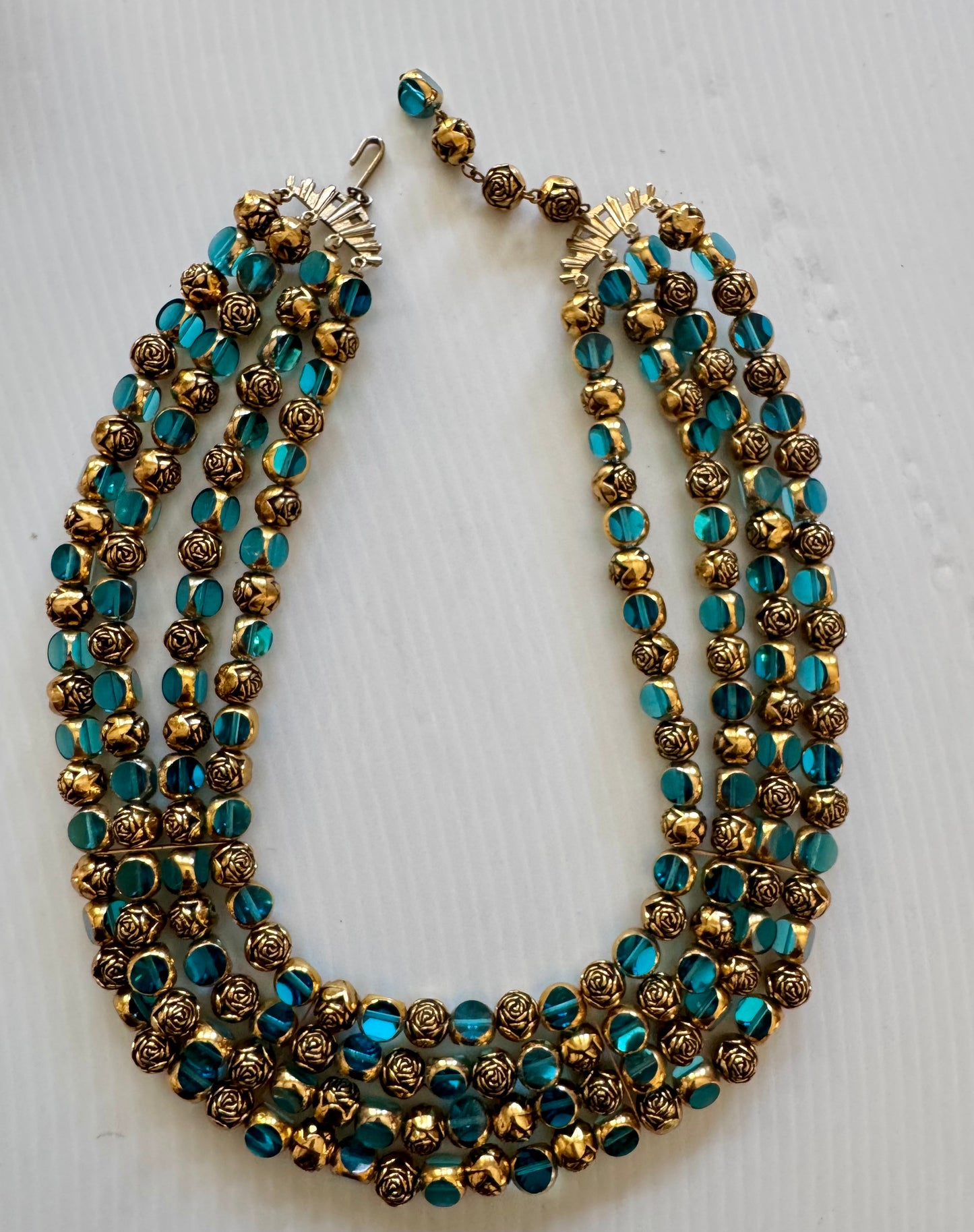 stunning vintage four strand, gold tone necklace with gold and turquoise beads. Sourced in Paris.