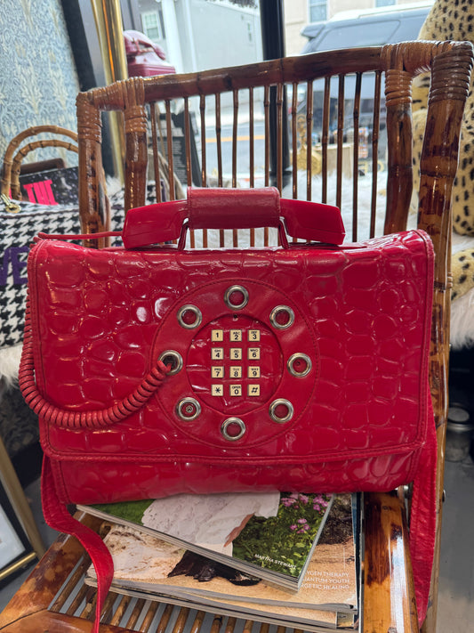 Vintage 1970s working (landline) red patent telephone handbag with top handle and crossbody strap.