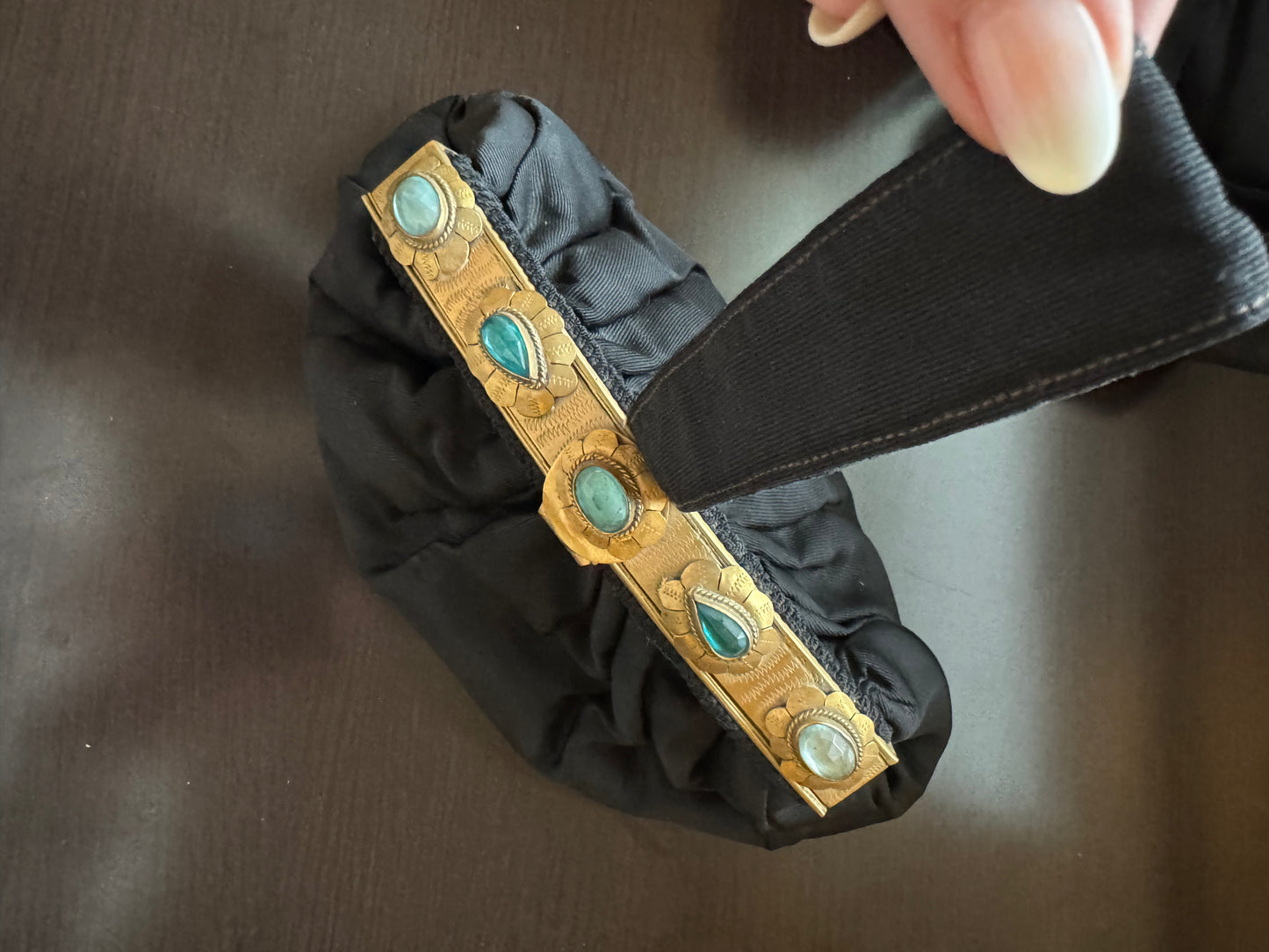 Stunning one of a kind 1920s black silk wristlet bag with decorative gold tone hardware and blue stones. A RARE collectors piece of history.