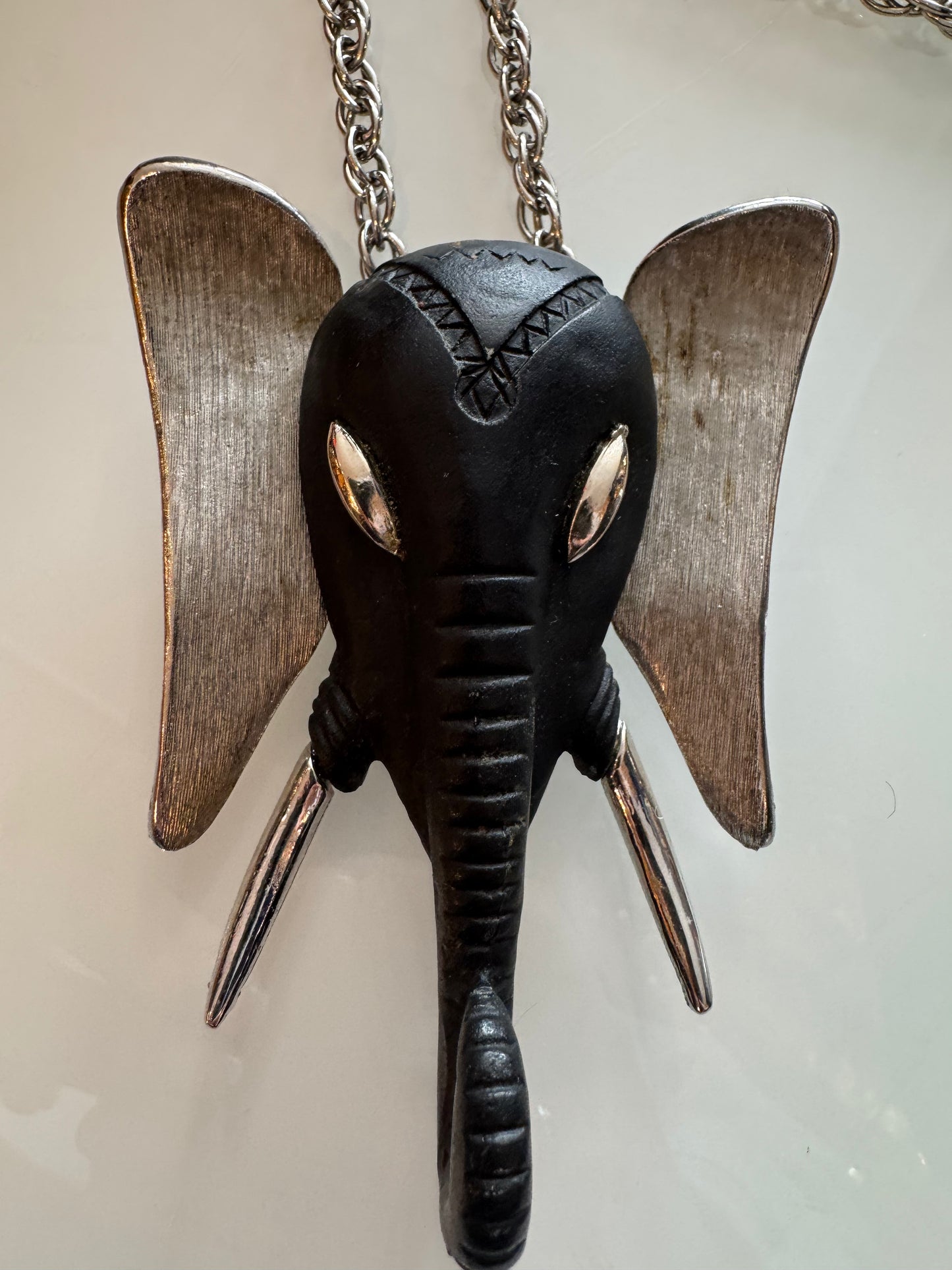Silver tone and black version of the infamous 1970s elephant head necklace
