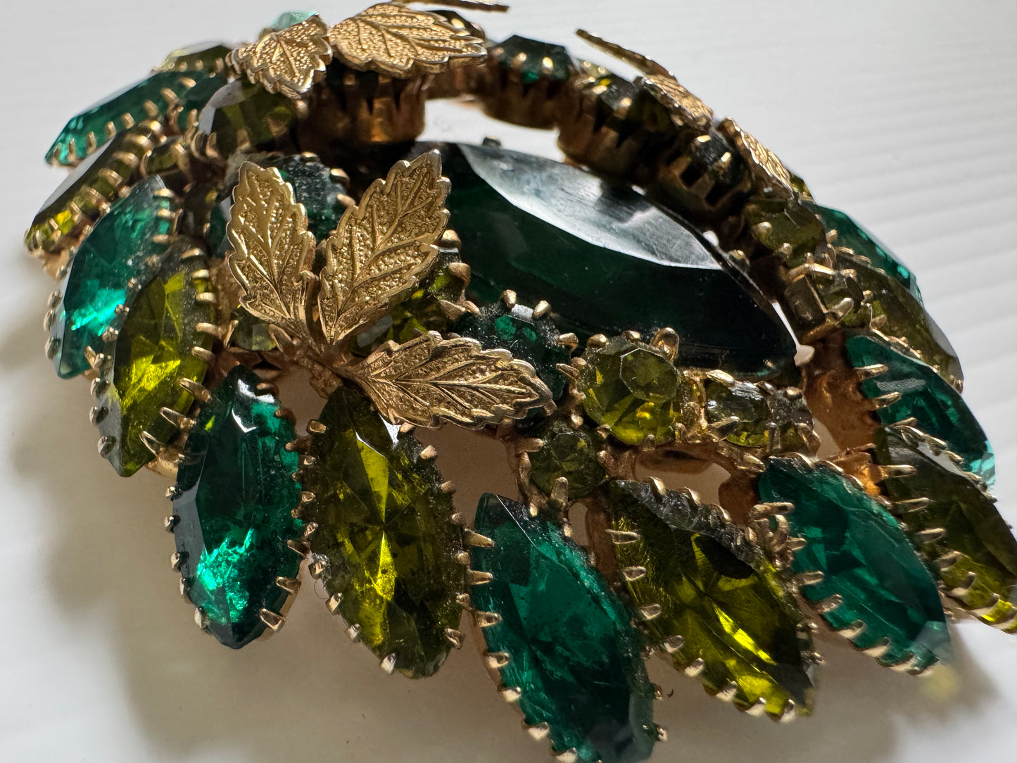 Wonderful jumbo Julianna 1940s brooch/pendant with shades of green rhinestones and gold leaf detail