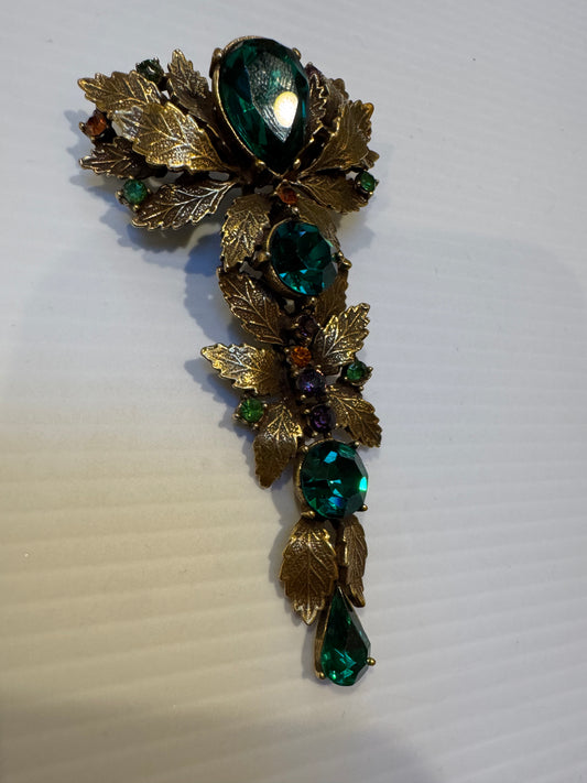 Tiny amber, topaz, purple, and peridot-toned rhinestones enhance the dimensionality of this signed CoroCraft 1940s brooch with cascading leaf motif. city