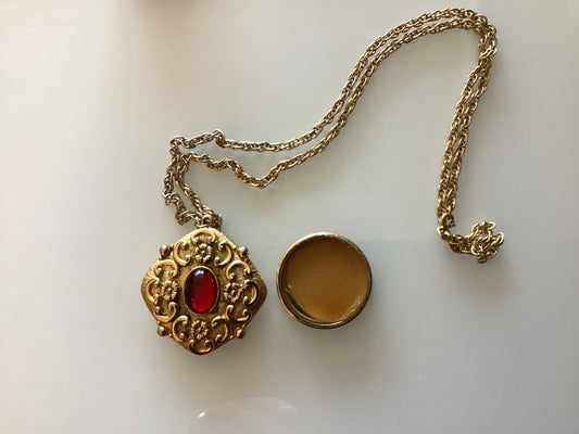 Vintage stunning fragrance pendant. Gold tone with red stone