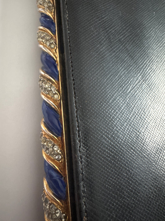 1960s signed Kenneth Lane black leather clutch with decorative blue enamel and rhinestone swirl frame