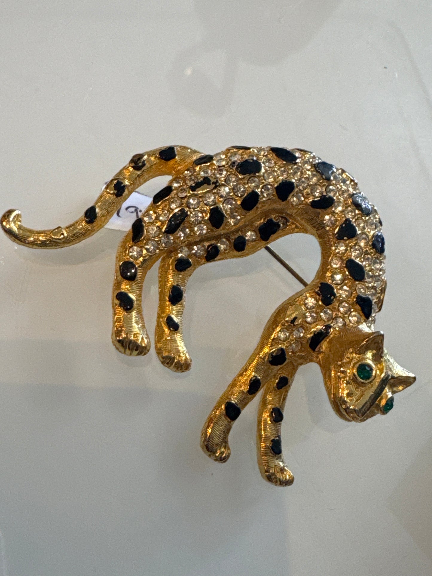 1960s panther brooch with clear, crystal rhinestones and emerald colored eyes. Black enamel spots ~ some need a little touchup, or not.