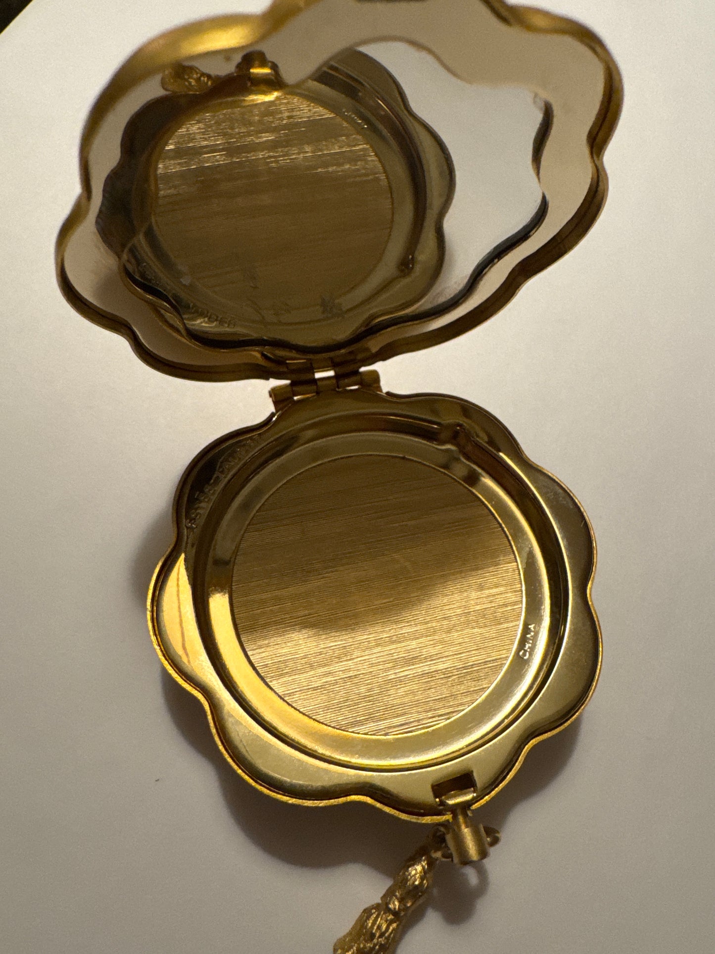 Vintage brushed gold Estée Lauder compact with red stones and tassel. Road