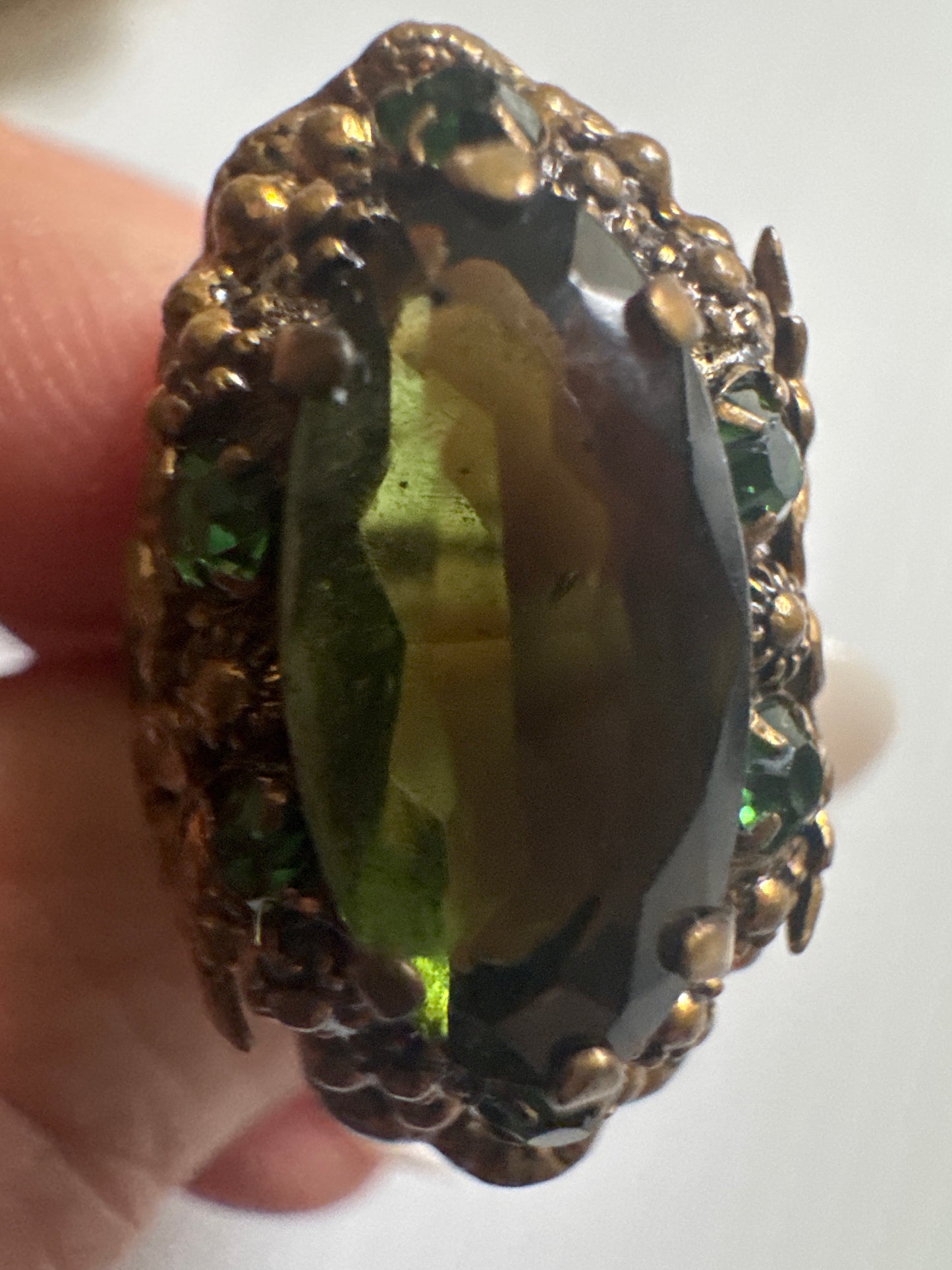 fabulous 1940s Czech glass ring with filigree detail, large green center stone and small green stones in setting