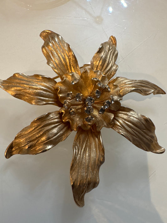 Beautiful gold tone flower brooch with rhinestone center