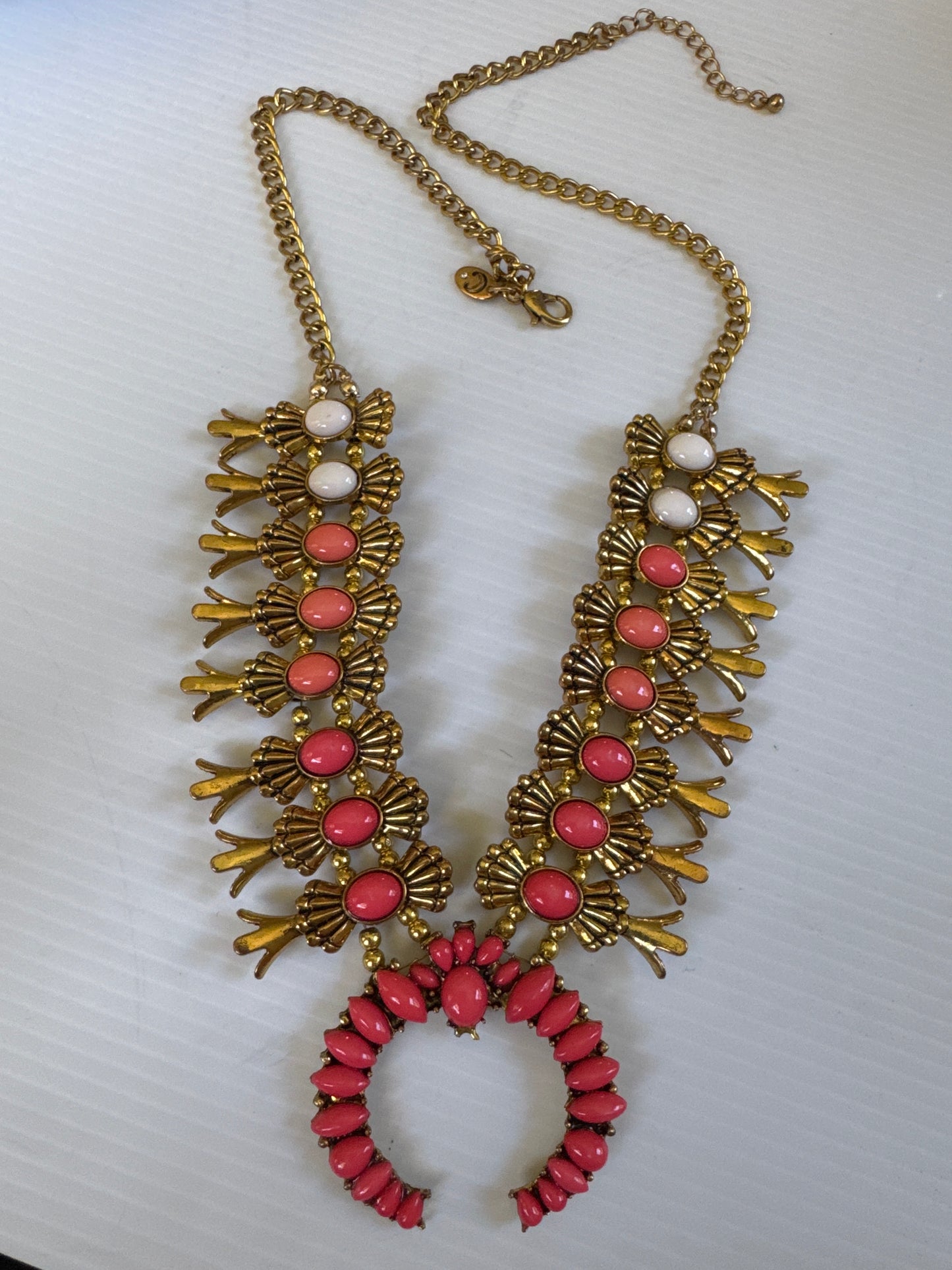 1990s adjustable squash blossom necklace in a gold tone setting with shades of coral stones