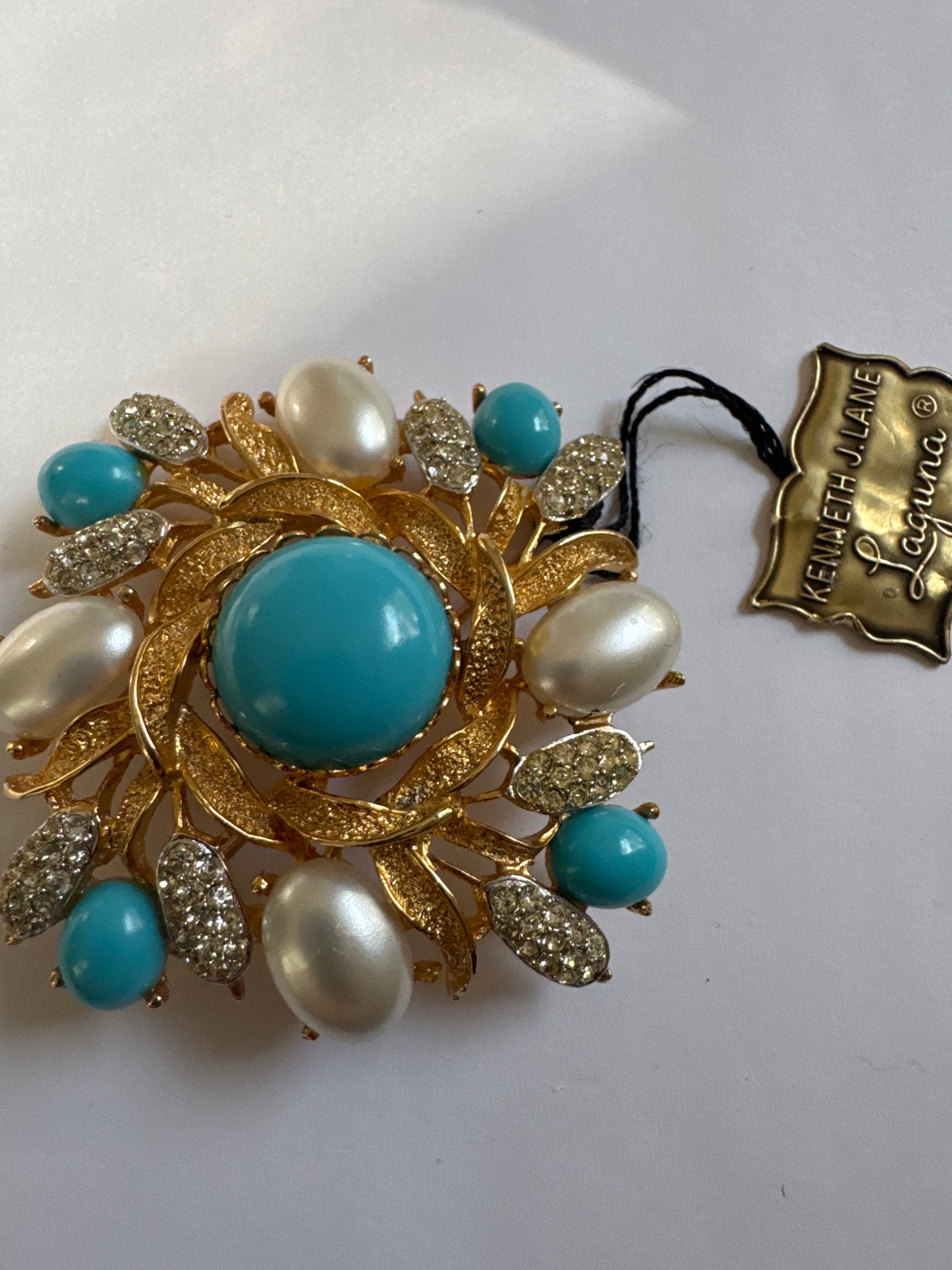 1960s vintage signed KJL Laguna gold tone, brooch with turquoise and faux pearl cabochon and clear rhinestones. Original tag attached.
