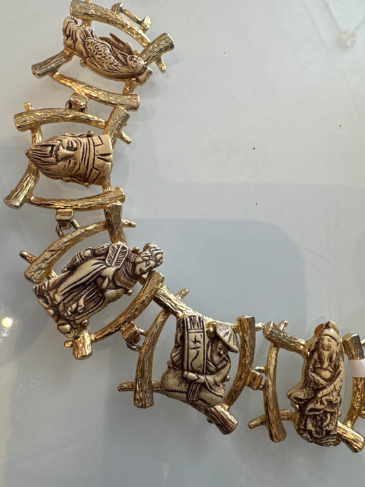 Sculptural mid-century bracelet featuring classical figural cameos set in richly textured gold-tone articulated links.