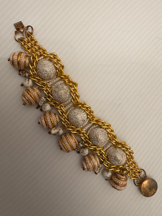 Playful, gold tone and white beaded dangle bracelet. PARIS LIVE