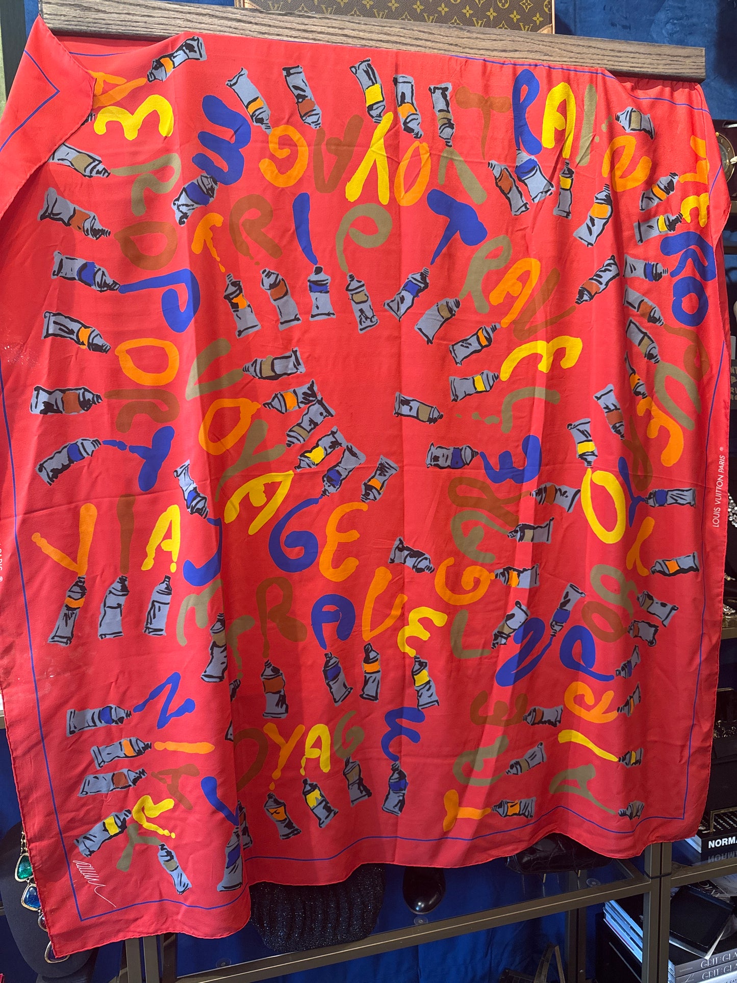 Vintage early 1990s Louis Vuitton red voyage silk scarf. Louis Vuitton “Le Temps d’un Voyage” scarf  is by Italian designer/architect Gae Aulenti, with scattered paint tubes with graffiti-style lettering and hand rolled edges.