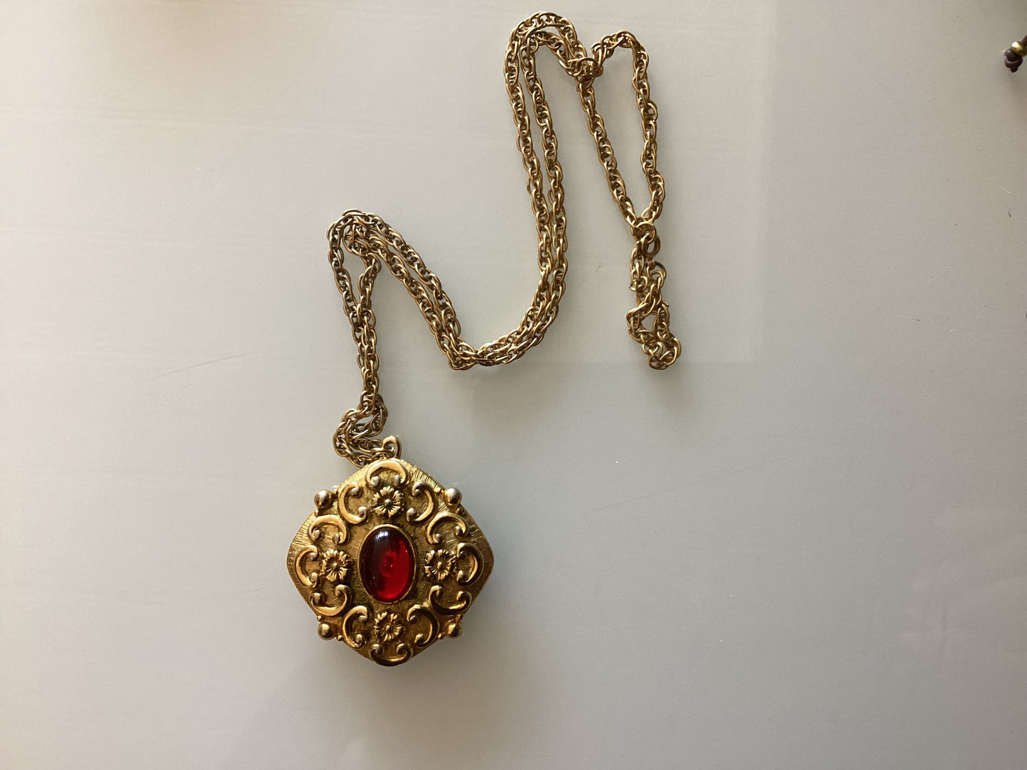 Vintage stunning fragrance pendant. Gold tone with red stone