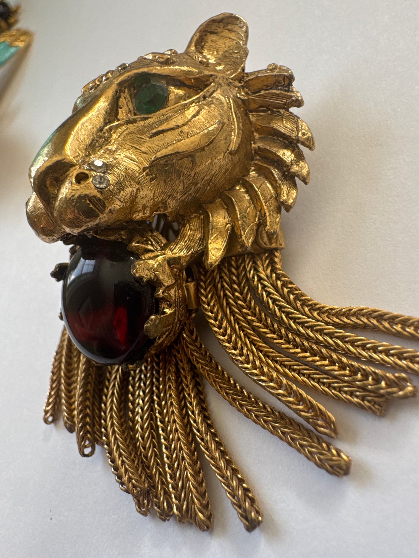 Coveted and hard to find 1960s unsigned lionhead tassel brooch attributed to Pauline Rader ~ this one being an amber glass cabochon with green rhinestone eyes. The wonderful coil fringe lions mane is fabulous.
