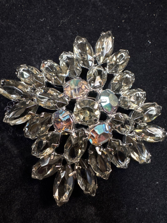 Beautiful 1950s Juliana brooch ~ slightly-domed silvertone metal and adorned by a burst of clear grey open-backed navettes.  In the center are five dark Aurora Borealis stones. NYC