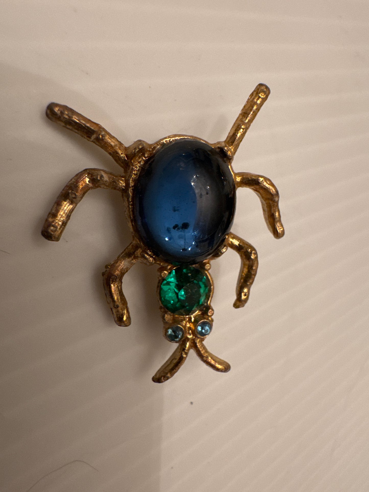 Unsigned vintage ant brooch, attributed to De Mario (NYC), circa late 1940s–early 1950s, identified by its deep cup-set cabochon body, emerald crystal head, and hand-finished gold-tone casting.