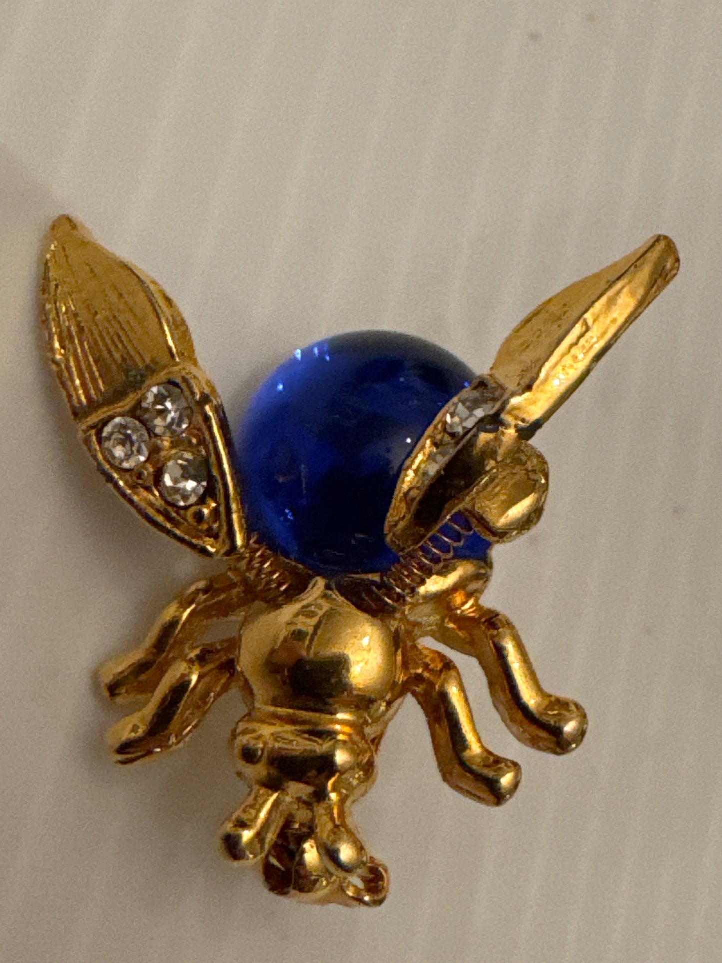 Unsigned vintage jelly belly trembler brooch attributed to Trifari (Alfred Philippe era), circa late 1940s, featuring a cobalt-blue glass cabochon body and spring-mounted tremble head. A RARE collectible.