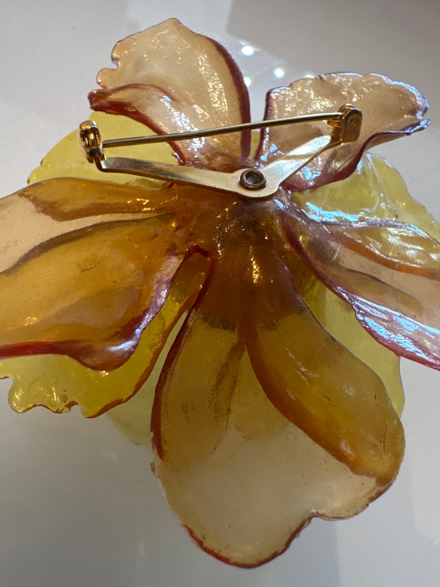 1960s 3-D yellow lucite brooch with green center rhinestones
