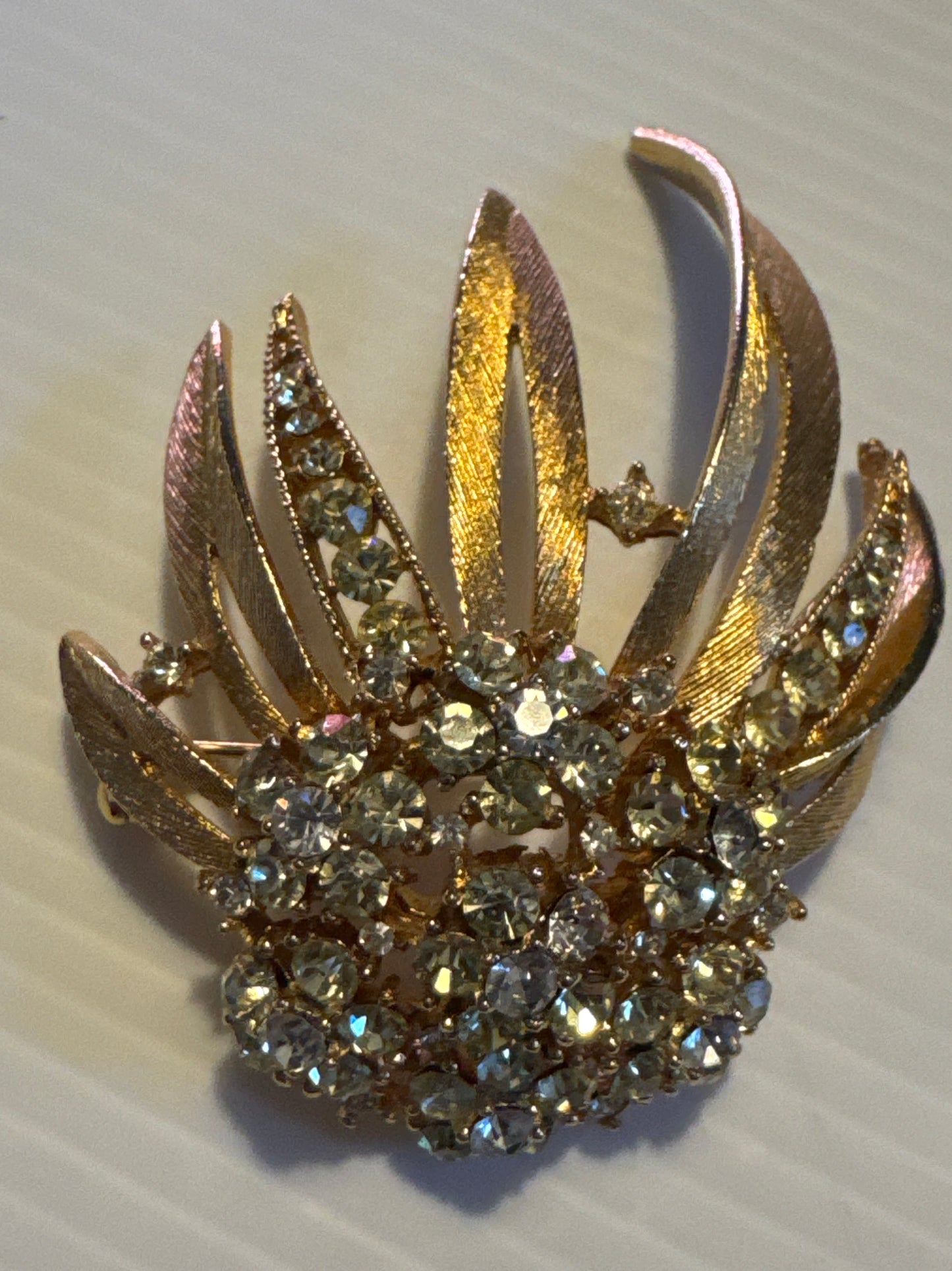 A beautiful mid-century Lisner brooch with soft champagne rhinestones and sculptural gold leaves.