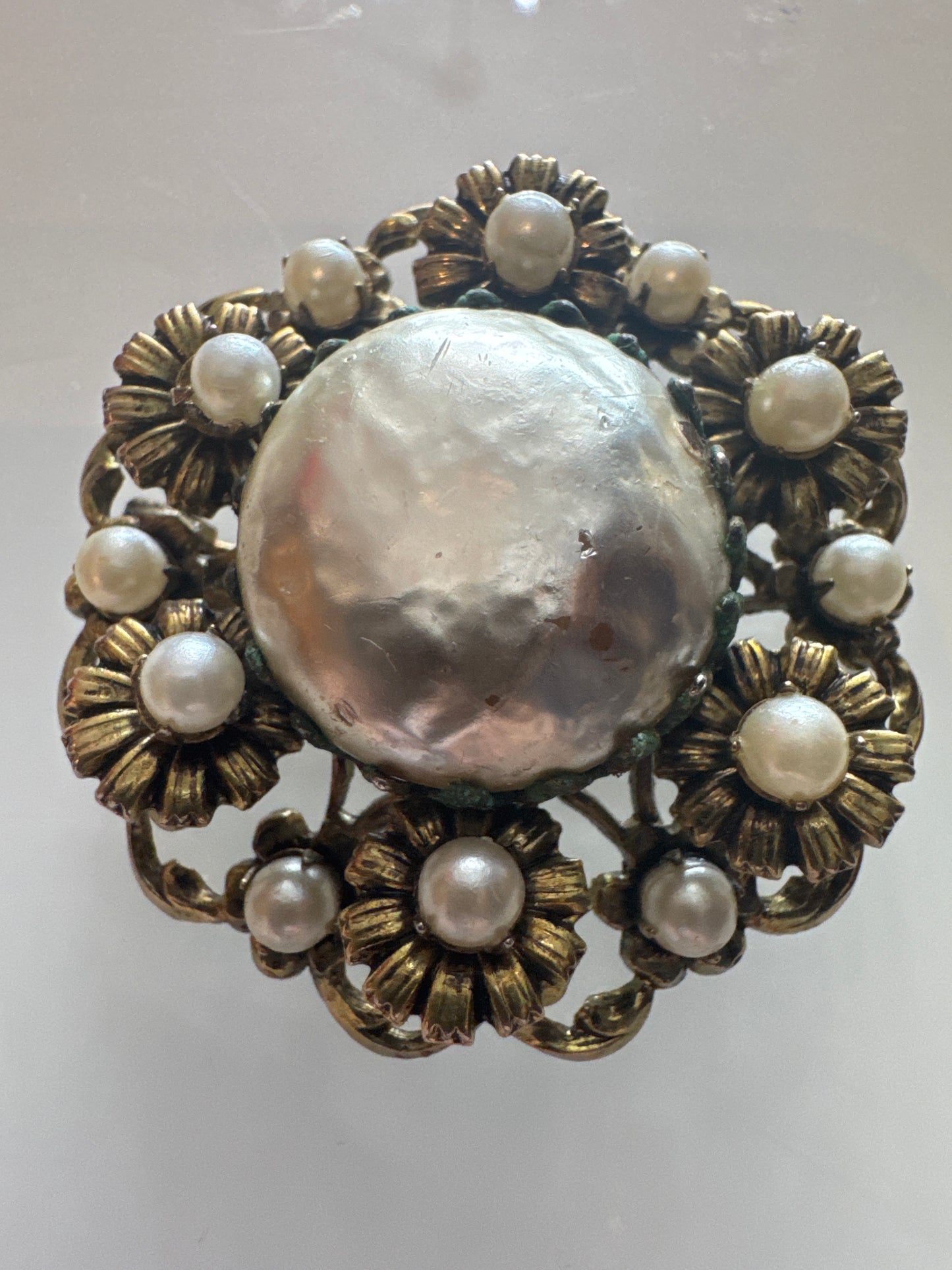Pearl and gold tone, circular flower pendant / brooch with filigree backing.