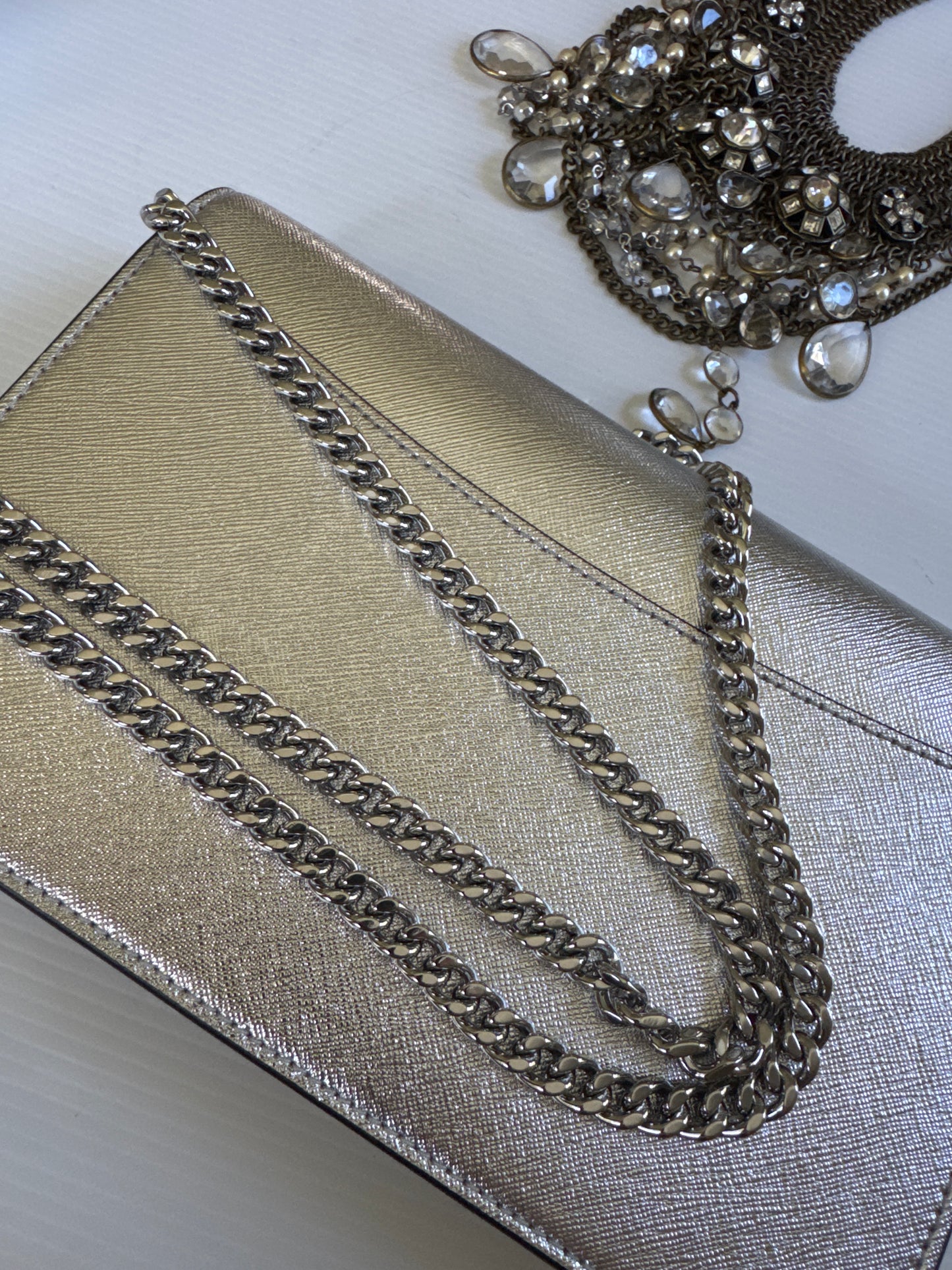 Never worn 1990s Marc Jacob's silver leather clutch with optional strap. Zippered interior and credit card slots plus a small back pocket.