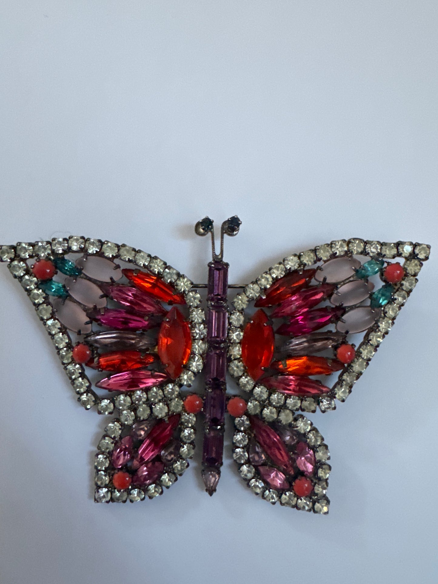 Late 1960s early 70s signed Kenneth Lane butterfly brooch featuring pink, orange and red rhinestones