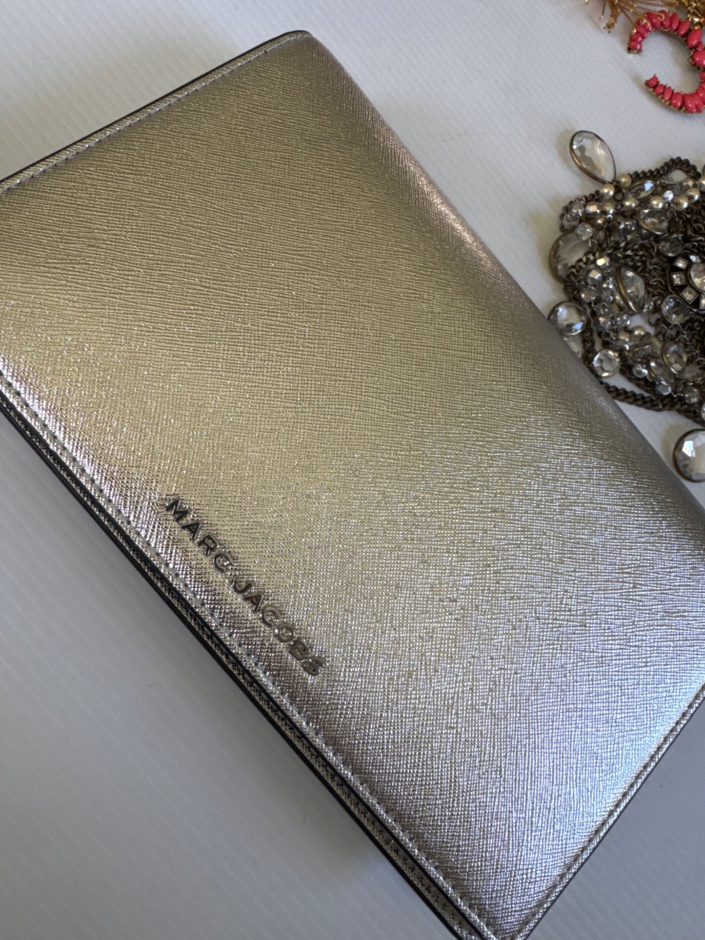 Never worn 1990s Marc Jacob's silver leather clutch with optional strap. Zippered interior and credit card slots plus a small back pocket.