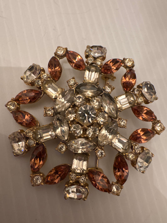 Unsigned brooch attributed to Schreiner New York, circa late 1950s. Identified by its unfoiled stones (creating a glow instead of a sparkle) dramatic mixed cuts, sculptural gold-tone casting, and signature dimensional construction