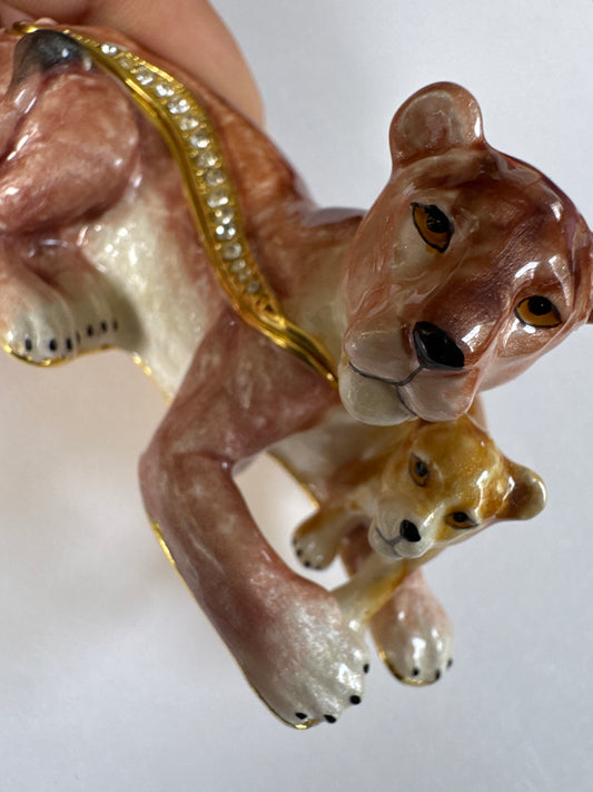 A charming 1980s enamel trinket box featuring a lioness and her cub—symbolizing protection and strength—finished with hand-painted detail and crystal accents.