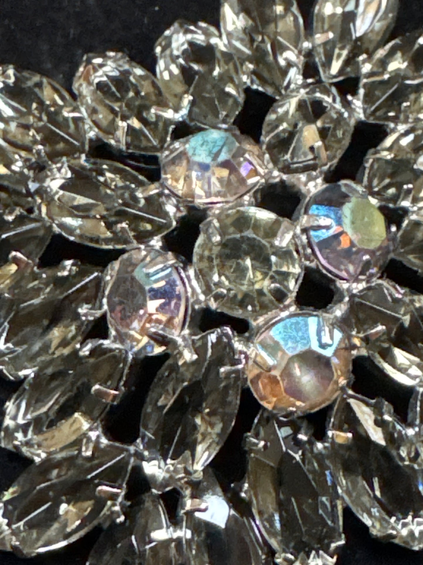 Beautiful 1950s Juliana brooch ~ slightly-domed silvertone metal and adorned by a burst of clear grey open-backed navettes.  In the center are five dark Aurora Borealis stones. NYC