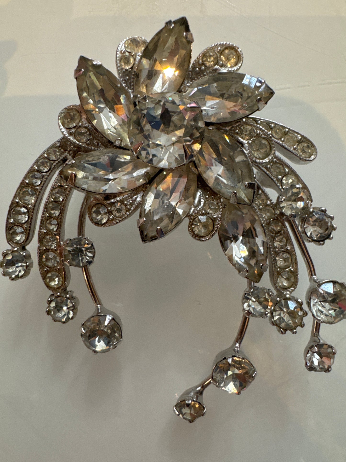 A dramatic mid-century Eisenberg Ice brooch featuring oversized marquise-cut crystals arranged in a radiant floral spray with cascading rhinestone drops. Crafted in rhodium-plated metal with exceptional brilliance and precision.