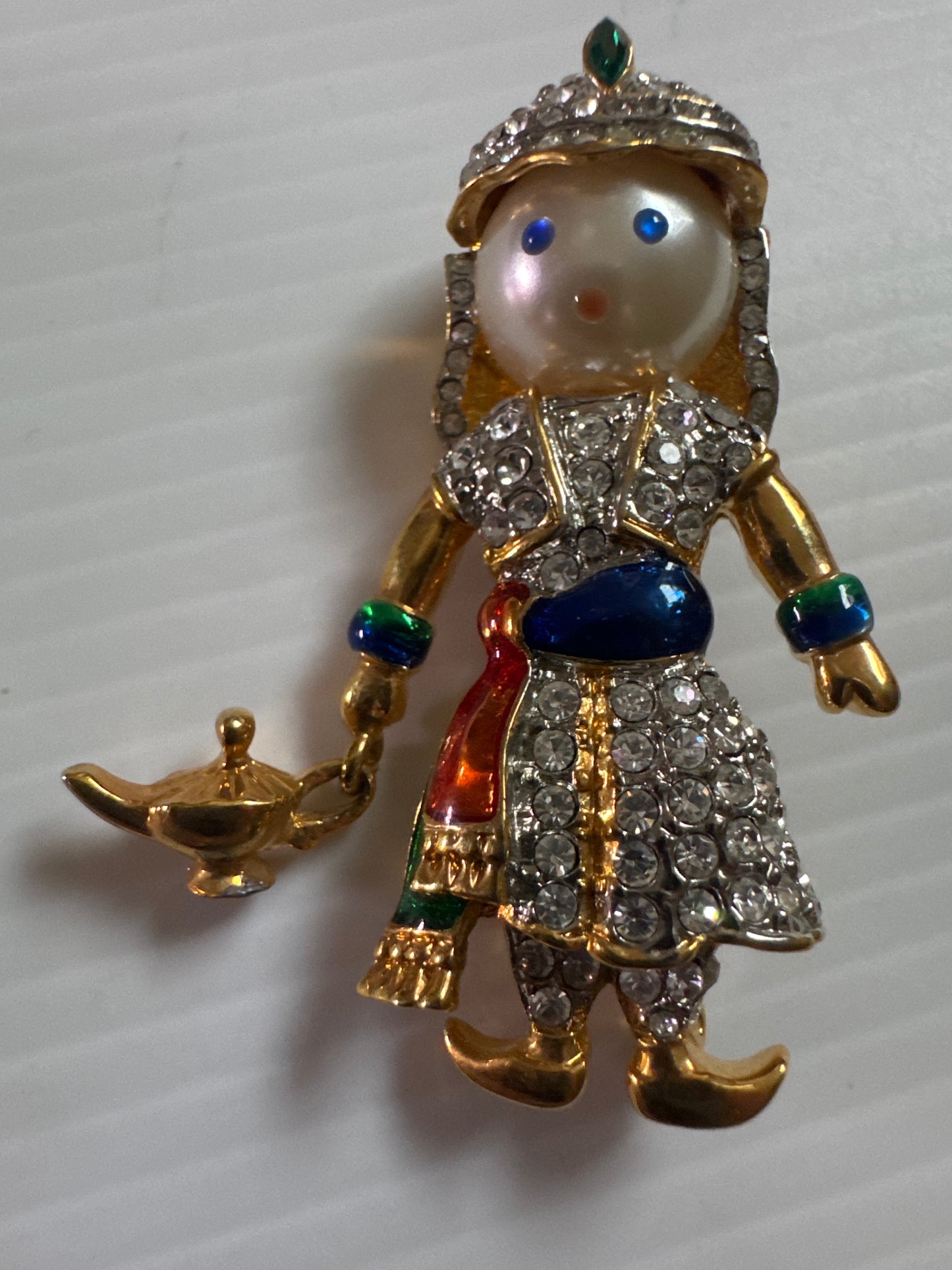 A whimsical 1980s vintage pair inspired by Arabian Nights fantasy—this figural duo features a genie and his companion, each richly detailed with hand-set rhinestones, enamel accents, and expressive pearlized faces.
