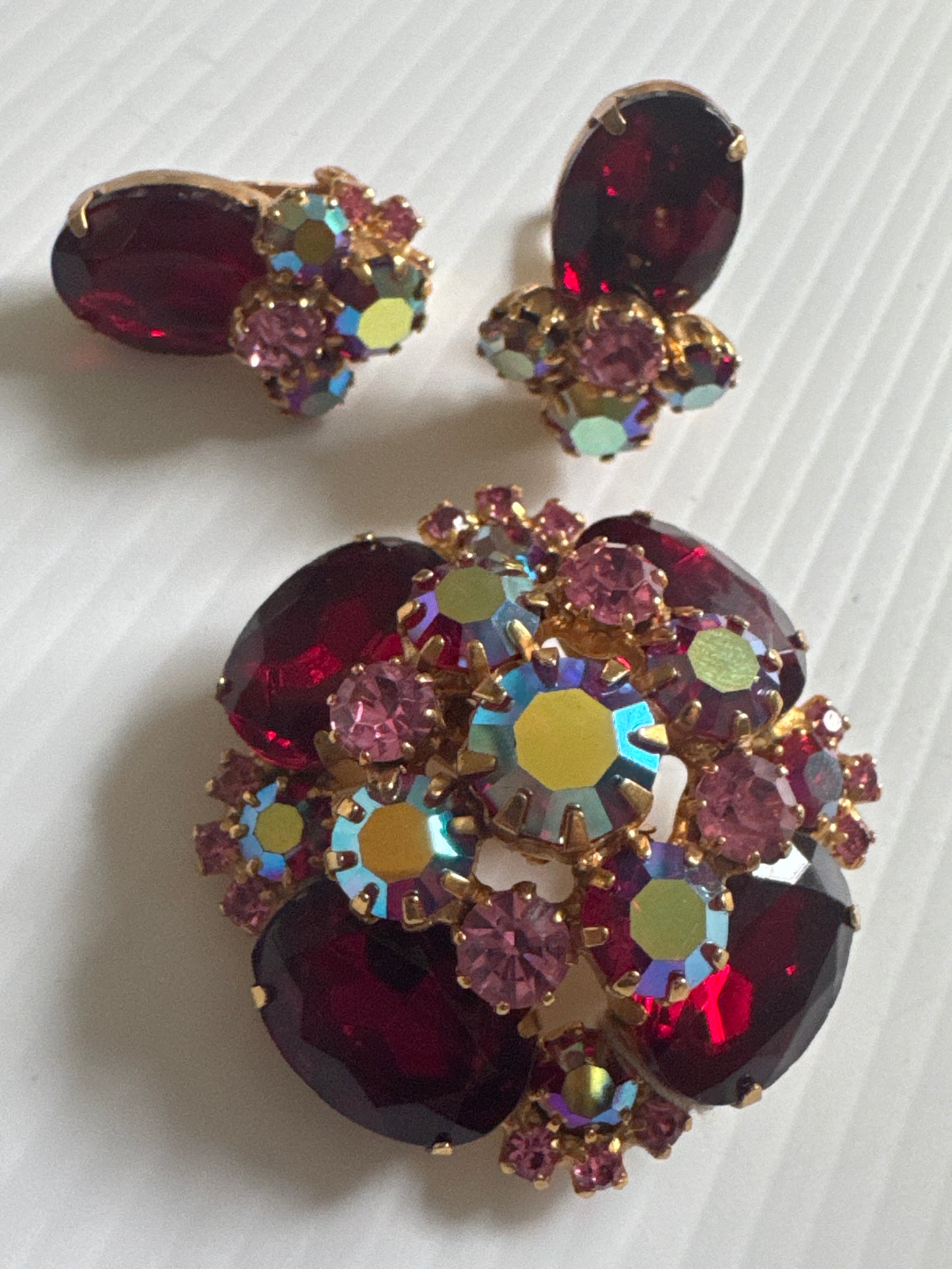 1950s stunning, brooch, and earrings set featuring red rhinestones and Aurora borealis